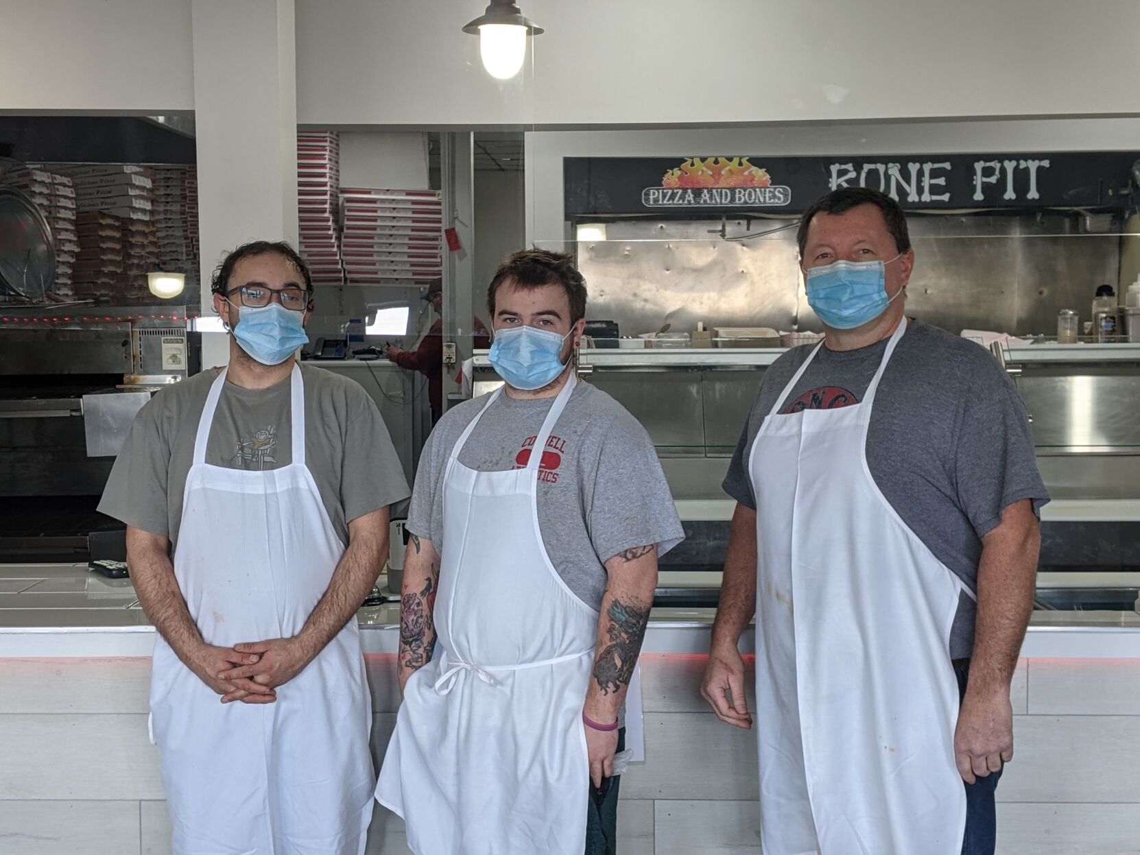 Owner Tim Todi (far right) and the rest of the staff of North East Pizza and Bones in the Village of Lansing.